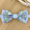 Nœud papillon à fleurs sur base bleue unie