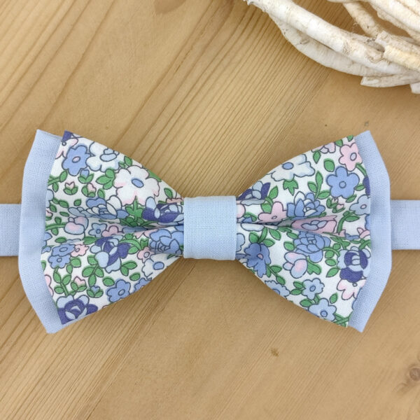 Nœud papillon à fleurs sur base bleue unie