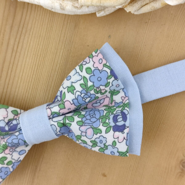 Nœud papillon à fleurs sur base bleue unie