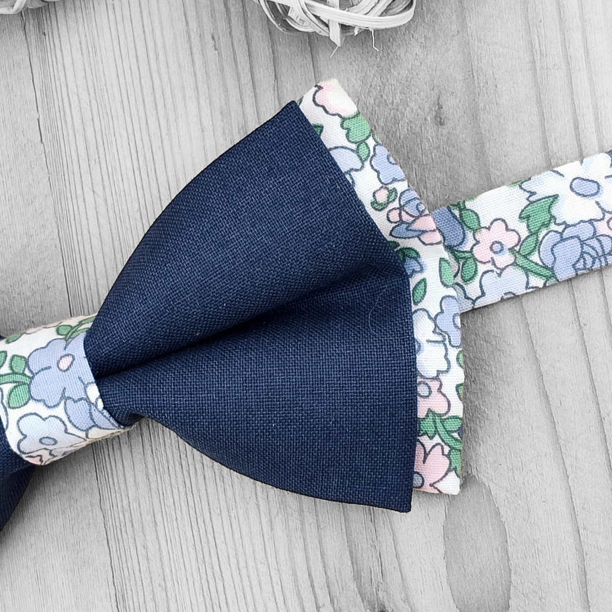 Nœud papillon bleu sur base fleurie